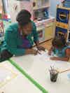 a woman and a child drawing on paper