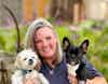 a woman holding two dogs
